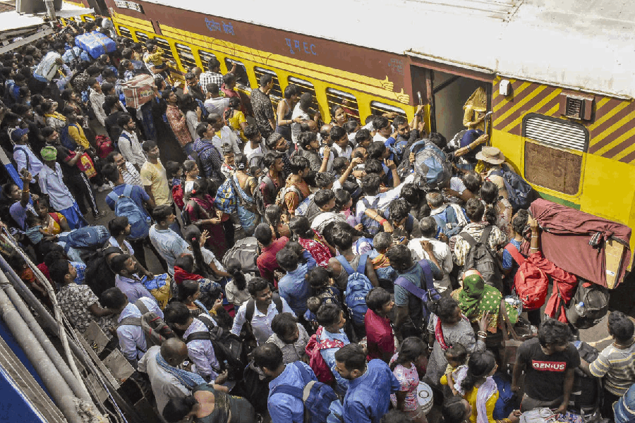 Passengers jostle to board a train at the Patna Junction railway station amid heavy rush ahead of the Chhath Puja festival, in Patna, Bihar, Friday, Oct. 24, 2025.