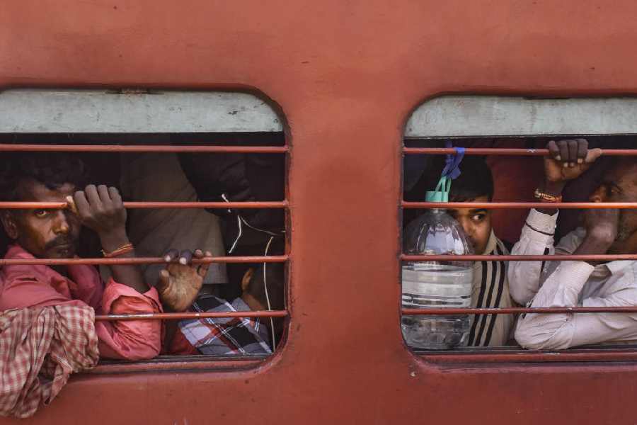 Passengers ride an overcrowded train ahead of the 'Chhath Puja' festival, at a railway station in Moradabad, UP
