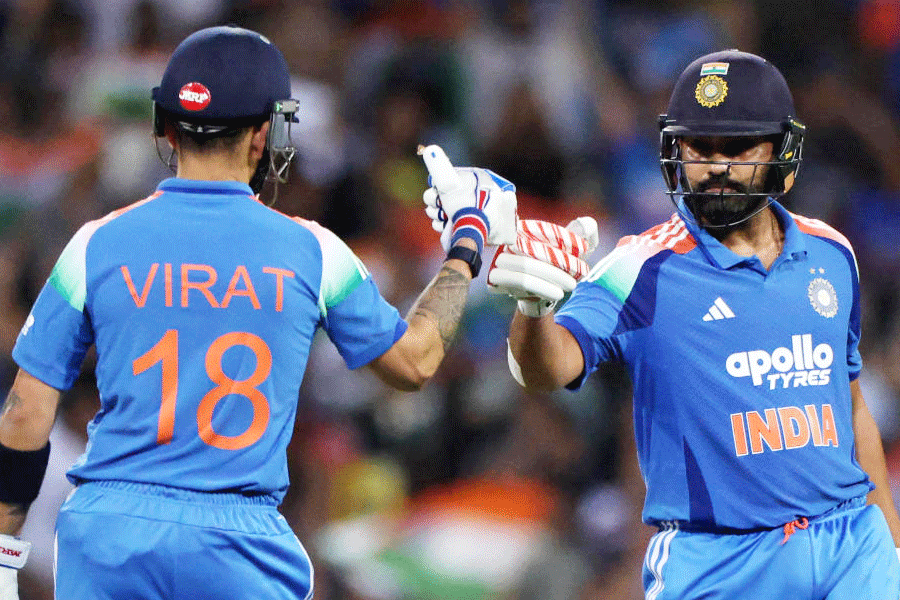 India's Rohit Sharma celebrates with Virat Kohli after hitting six runs off the bowling of Australia's Adam Zampa.