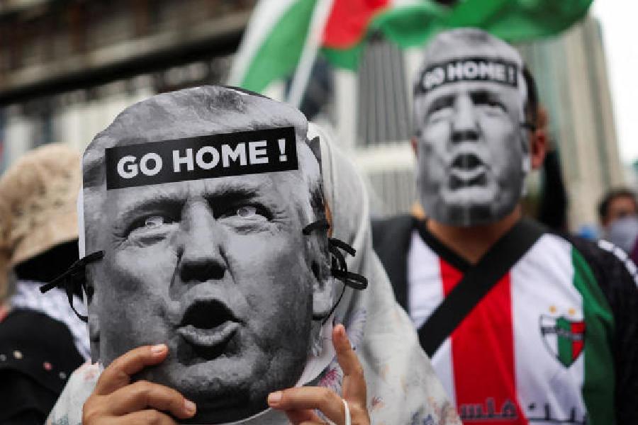 Pro-Palestinian demonstrators hold cutouts depicting Donald Trump’s face as they march towards the US embassy in Kuala Lumpur on Friday to protest the President’s visit to Malaysia for the Asean summit.