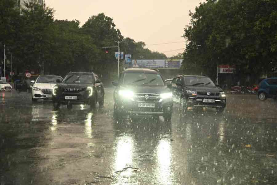 Vehicles move amid rain on Hospital Road on Sunday afternoon.Picture by Bishwarup Dutta