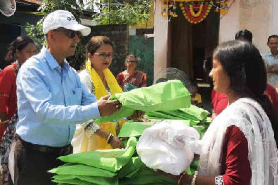 Trinamool veteran and mayor Gautam Deb distributes items to devotees for Chhath Puja in Siliguri on Sunday. Picture by Passang Yolmo