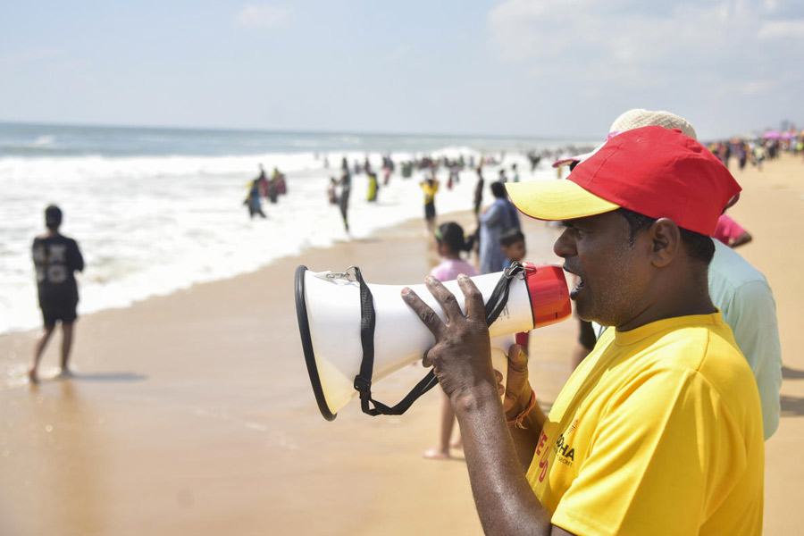 A life guard urges visitors not to venture too deep into the sea in view of 'Cyclone Montha', in Puri.