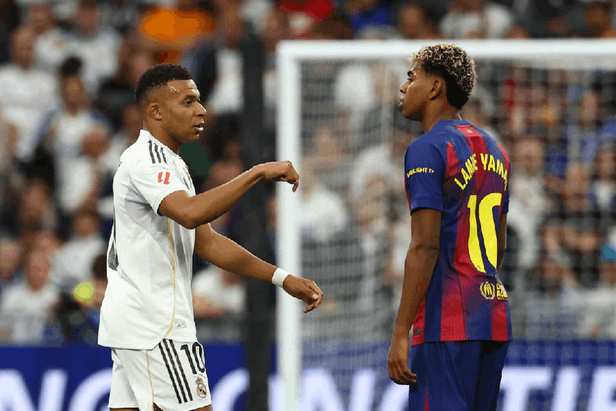 Real Madrid's Kylian Mbappe celebrates scoring their first goal as FC Barcelona's Lamine Yamal looks on.