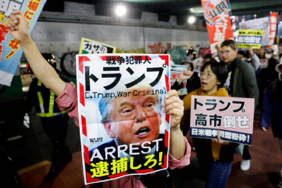 A protester holds a poster seeking the arrest of Donald Trump during a rally against Trump’s visit to Japan in Tokyo on Monday.