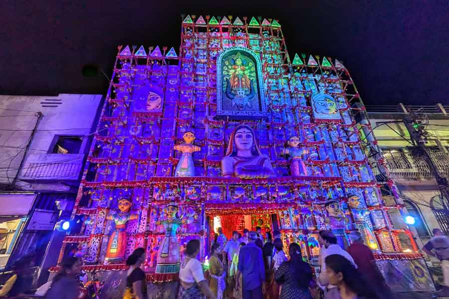 A pandal front, decked in handcrafted figures and mythological motifs, draws visitors in with its vibrant hues