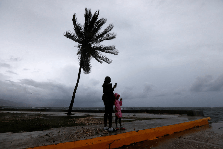 A woman and a child stand along the Kingston waterfront as Hurricane Melissa approaches, in Kingston, Jamaica.