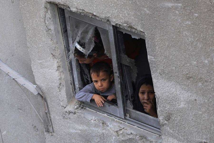 A Palestinian child looks out of a window, near a house hit in an overnight Israeli strike, in Gaza City, October 29, 2025.