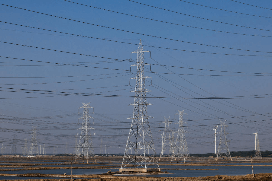 File photo: A view shows high-tension electricity power line pylons and power generating windmill turbines on Ahmedabad-Bhuj national highway near Surajbari village in the western state of Gujarat, India, November 28, 2024.
