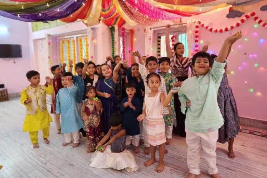 Kids of Little Einsteins hold up their diyas before Diwali.