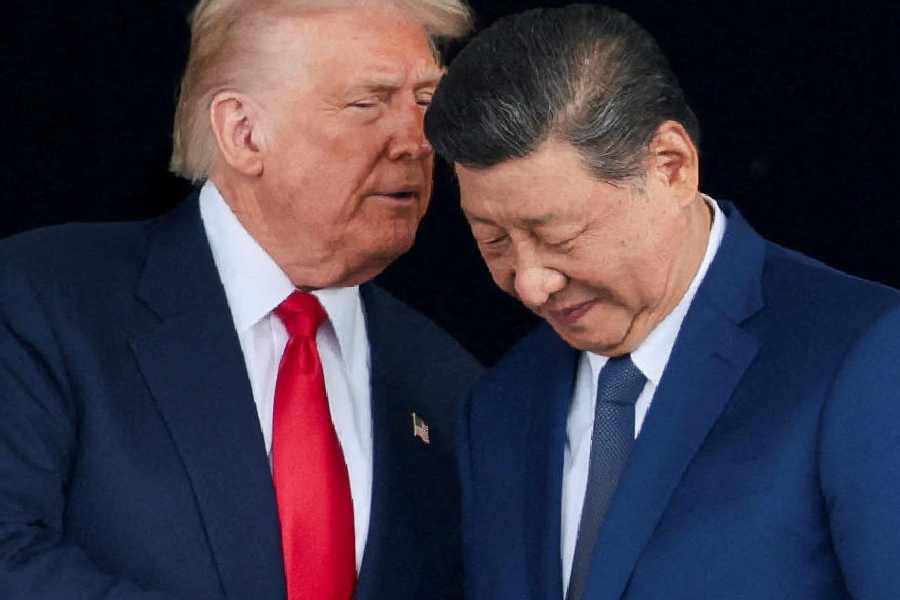 Trump and Xi Jinping talk as they leave after a bilateral meeting, on the sidelines of the APEC summit, in Busan