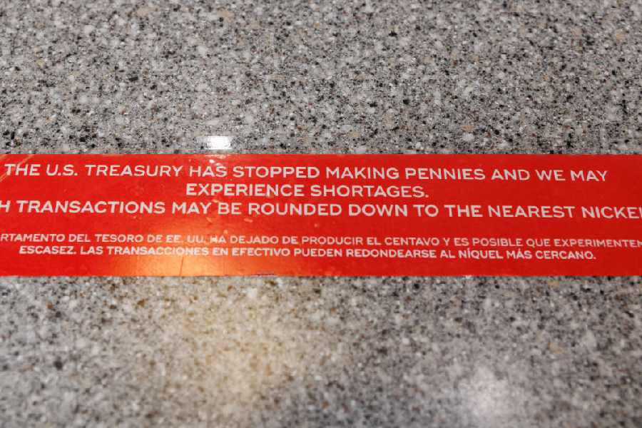 Signage placed on a checkout counter indicates a penny shortage at a QuikTrip in Dallas, Texas, U.S