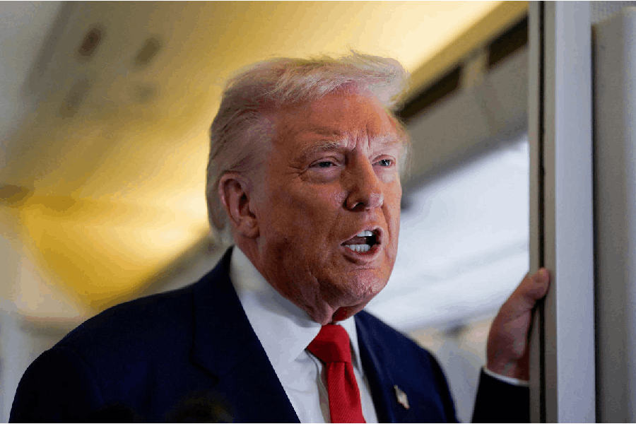 U.S. President Donald Trump speaks to members of the media aboard Air Force One as he departs for Florida from Joint Base Andrews, Maryland, U.S., October 31, 2025.