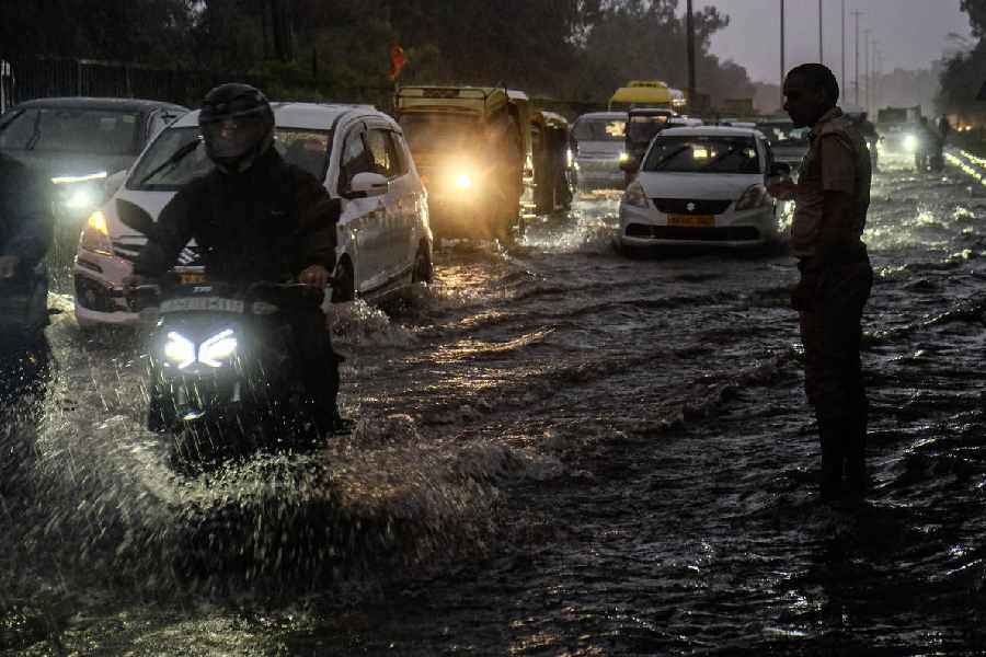 A security personnel keeps vigil as commuters make their way through the waterlogged Delhi-Gurugram expressway amid rainfall, in Gurugram, Monday, Sept. 1, 2025.