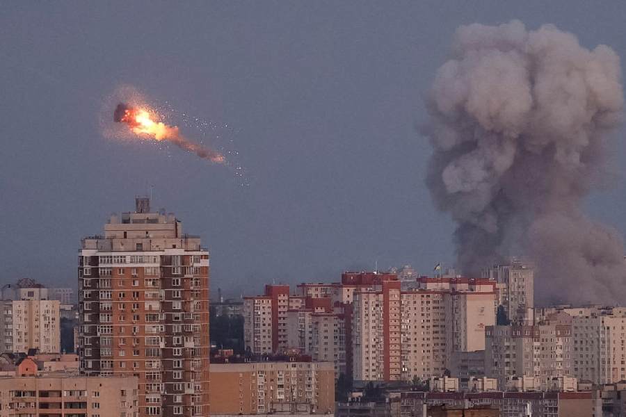 Ukrainian servicemen shoot down a Russian missile as smoke rises from the city during a Russian missile strike(REUTERS)
