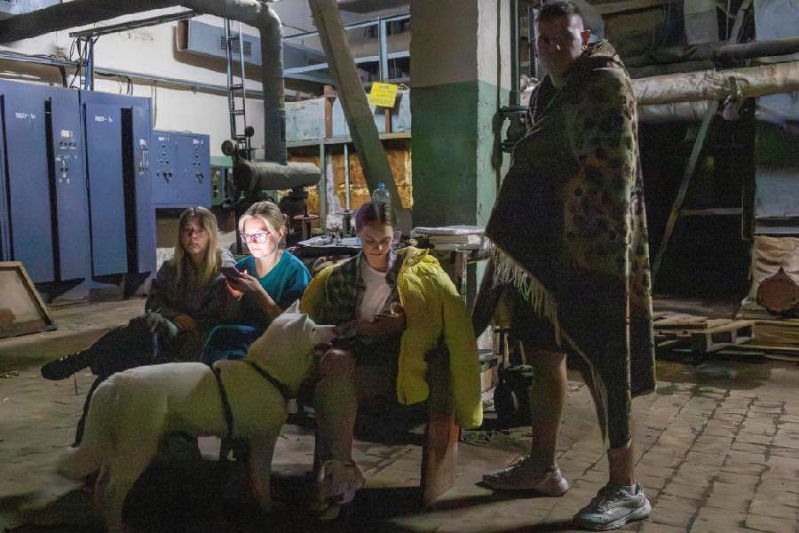 People hide in a shelter during an air raid alarm after a nearby apartment building was damaged(REUTERS)