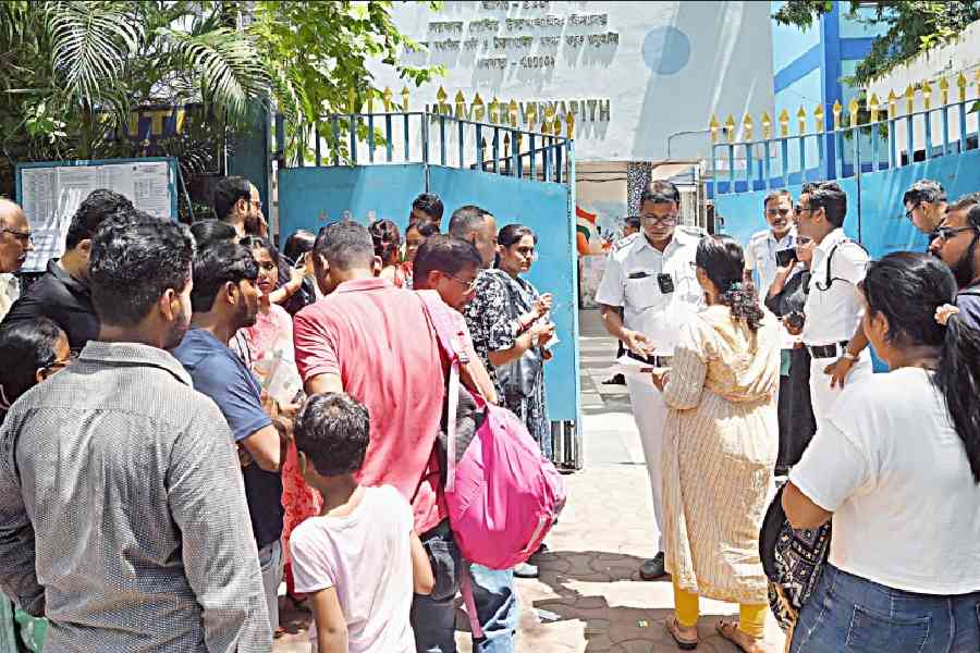 A police officer checks the documents of an SSC candidate at the gate of Jadavpur Vidyapith, an exam centre, on Sunday. Pictures by Bishwarup Dutta