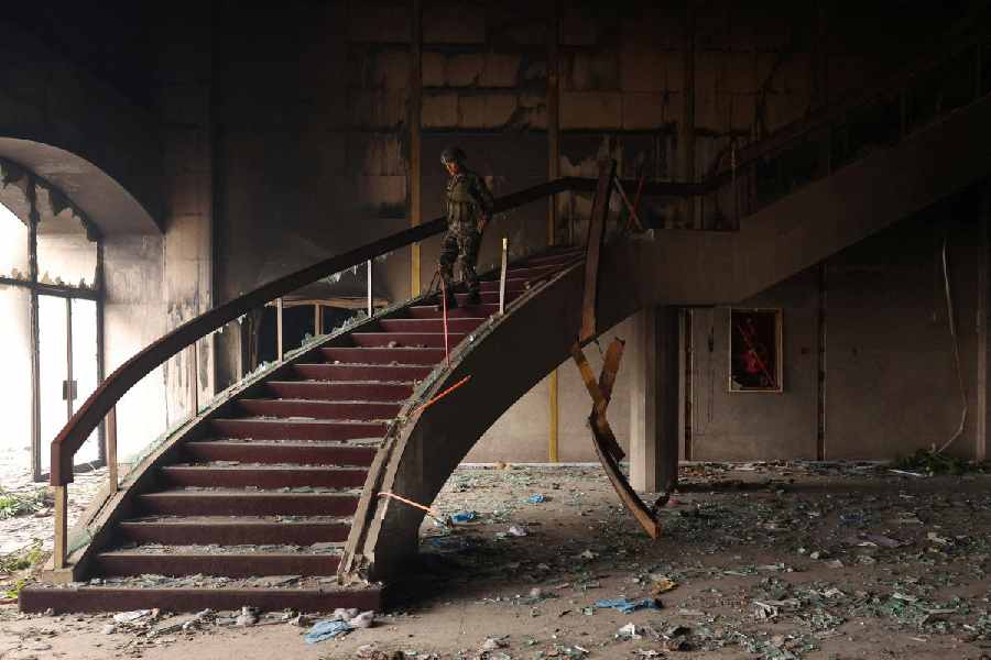 A Nepali Army soldier walks down the stairs of the Parliament house which was set on fire by the protesters.
