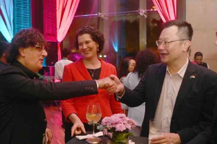 Didier Talpain greets Kevin Goh, the acting Australian consul general, as US consul general Kathy Giles-Diaz looks on