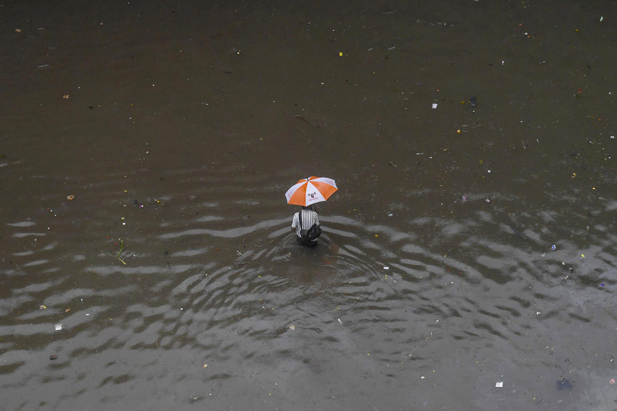 A commuter makes his way through a waterlogged road amid rainfall in Mumbai.
