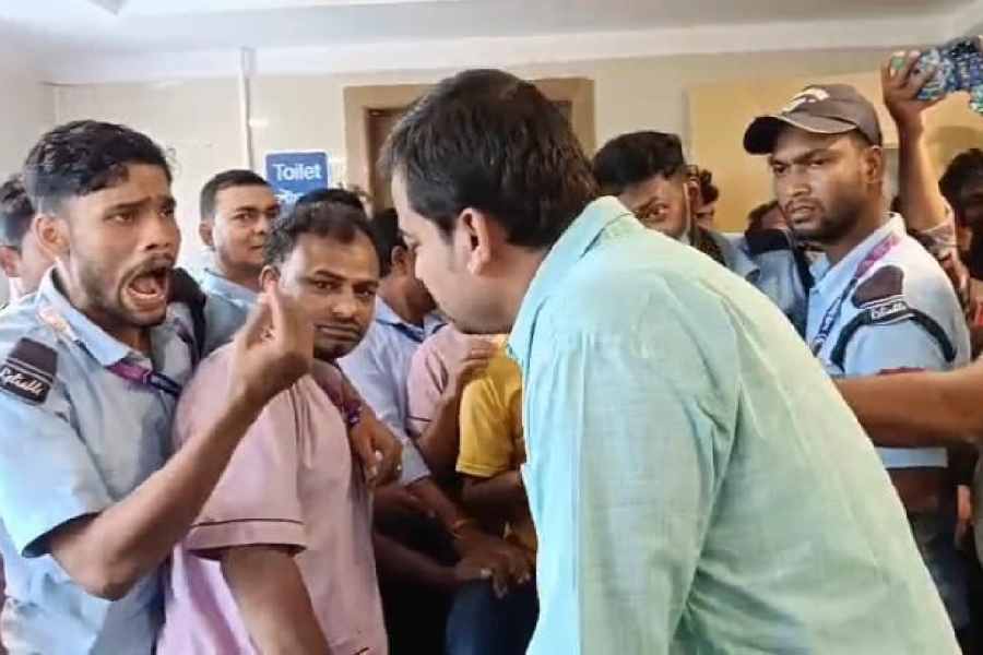 Employees protest in front of an official of the Panskura Super Speciality Hospital on Tuesday. 