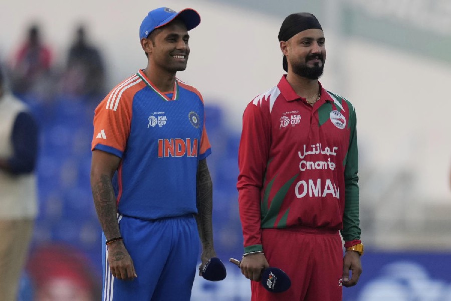 India's captain Suryakumar Yadav, left, and Oman's Captain Jatinder Singh stands to toss a coin during the Asia Cup cricket match between India and Oman at Zayed Cricket Stadium in Abu Dhabi, United Arab Emirates, Friday, Sept. 19, 2025.