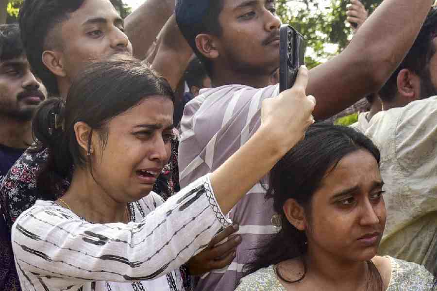 People mourn and take pictures as the mortal remains of singer Zubeen Garg are taken to his residence from Guwahati airport, Sunday, Sept. 21, 2025.