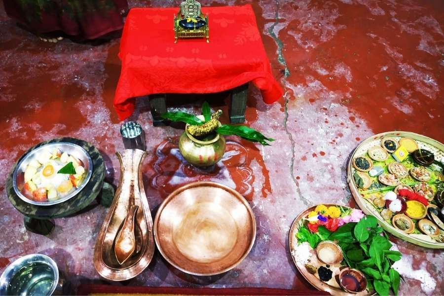 The family gathers at the Durga mandap for Prastar Bandhan Puja, where typical Bijoya sweets are offered as prasad