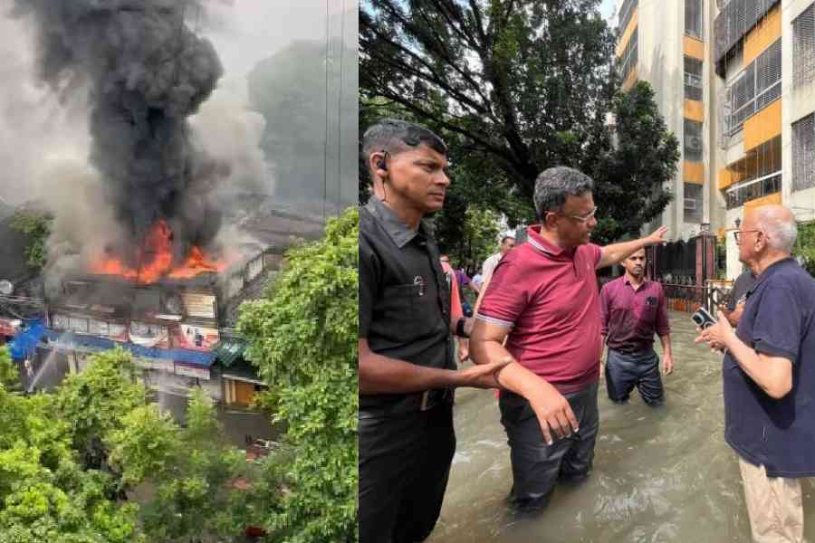 Smoke billowing from the blaze at Mandeville Garden, Mayor Firhad Hakim talks to a resident of Mandeville Gardens about the blaze on Tuesday morning