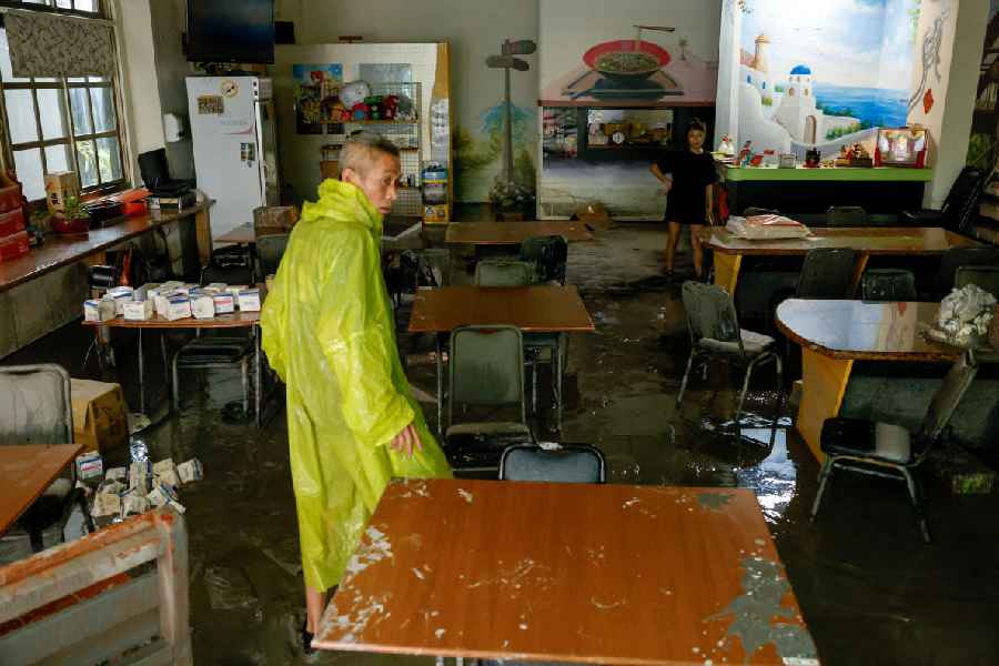 A restaurant owner stands in their mud-covered restaurant brought in by flooding after Super Typhoon Ragasa in Hualien, Taiwan, September 24, 2025.