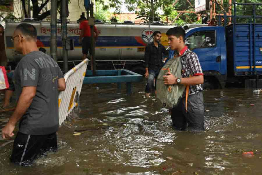 A student wades through a waterlogged AJC Bose Road on Tuesday. Picture by Bishwarup Dutta