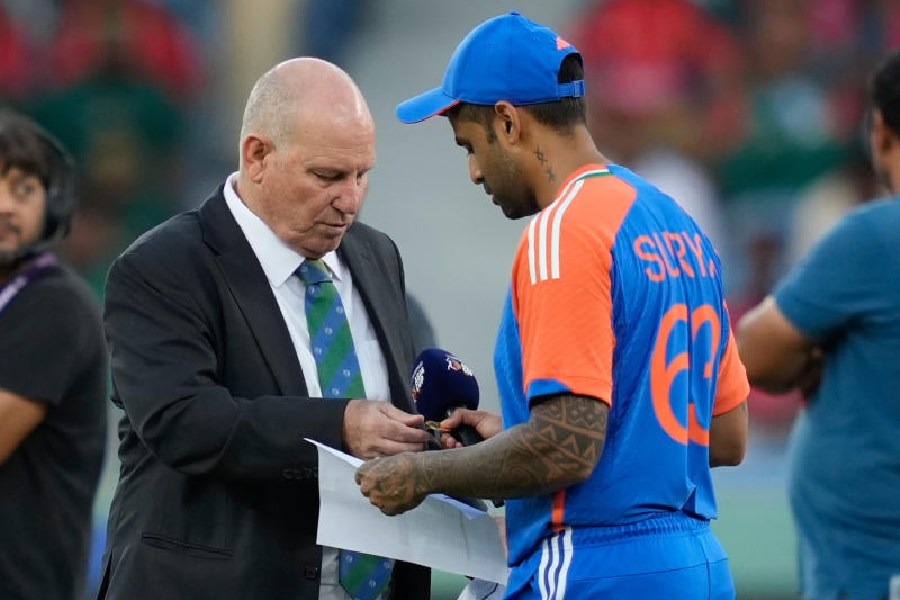India's captain Suryakumar Yadav, right, shares team list with match referee Andy Pycroft at the toss during the Asia Cup cricket match between India and Bangladesh at Dubai International Cricket Stadium in Dubai, United Arab Emirates, Wednesday, Sept. 24, 2025.
