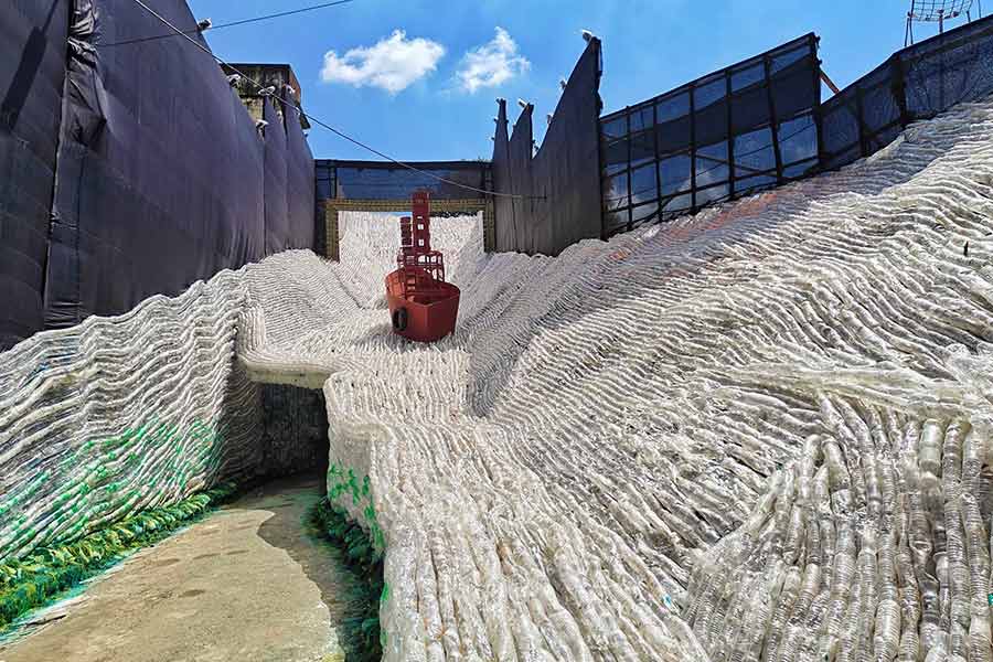 The pandal is crafted with lakhs of discarded plastic bottles and other forms of single-use plastic, transformed into a hauntingly beautiful yet thought-provoking setting