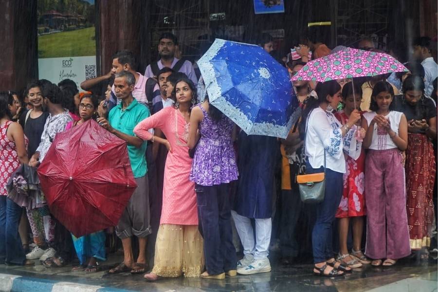 Pandal-hoppers in south Kolkata take cover as brief and sharp spells of rain hit the city