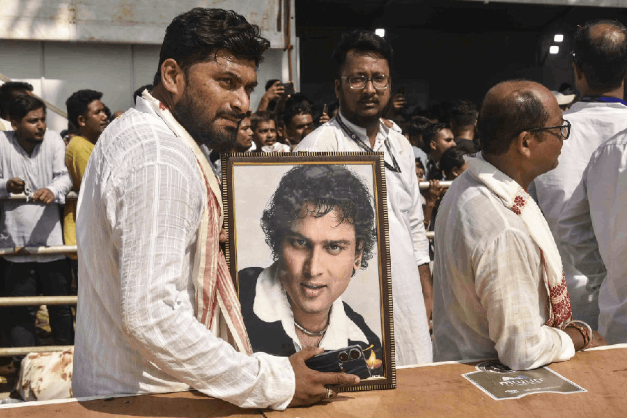 A fan holds a portrait of late singer Zubeen Garg during his last rites at the cremation ground in Sonapur, Assam, Tuesday, Sept. 23, 2025.