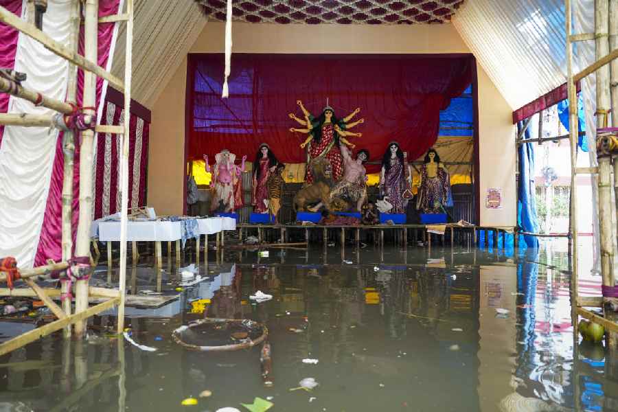 Idols of Goddess Durga placed on a raised structure after rainwater inundated the pandal, ahead of the 'Durga Puja' festival