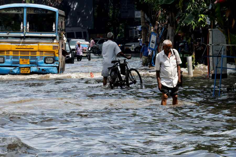 People wade through a waterlogged road after heavy rainfall in Kolkata, India, September 24, 2025