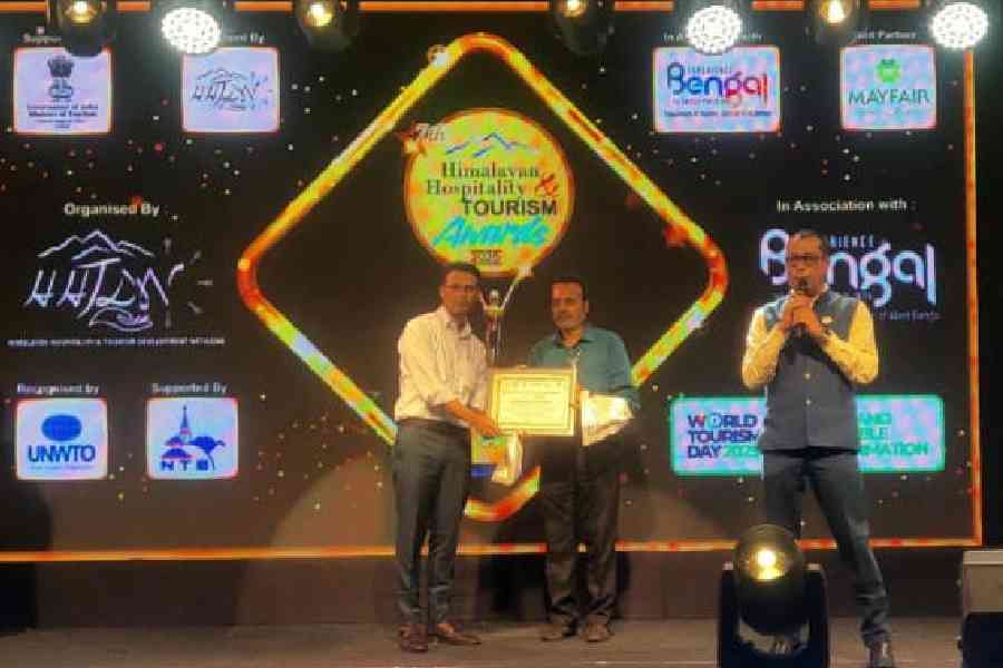 Pradip Kumar Dhanuka (centre) receives the lifetime achievement award, posthumously conferred on Kalyan Deb, on behalf of his family, in Siliguri on Saturday