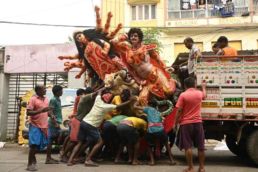 In Kumartuli, people load idols onto a truck on Saturday morning.