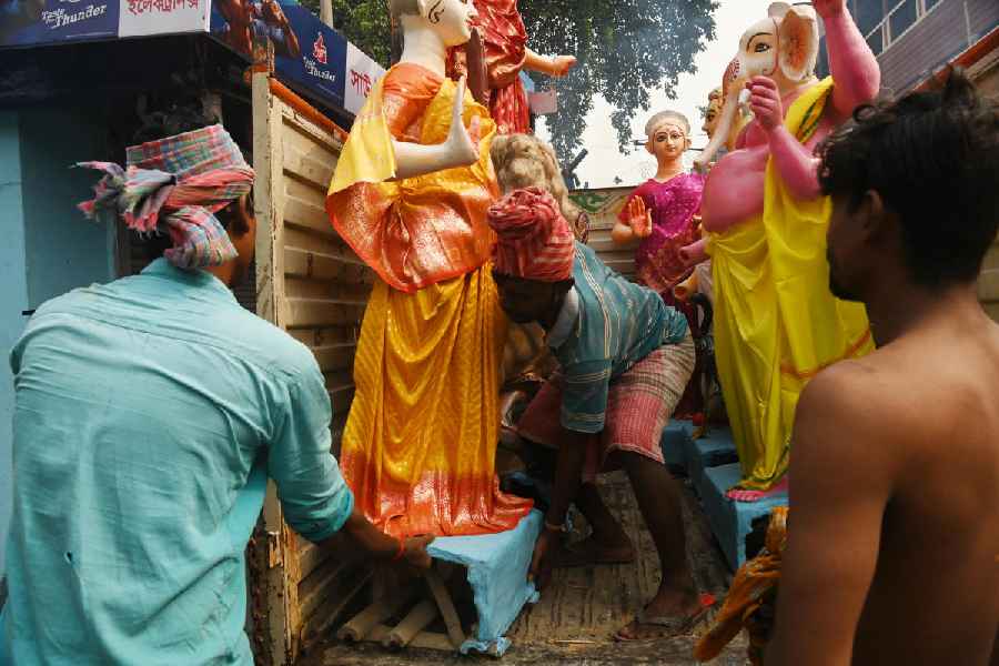 In Kumartuli, people load idols onto a truck on Saturday morning.
