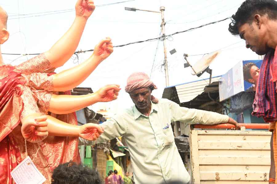 In Kumartuli, people load idols onto a truck on Saturday morning.