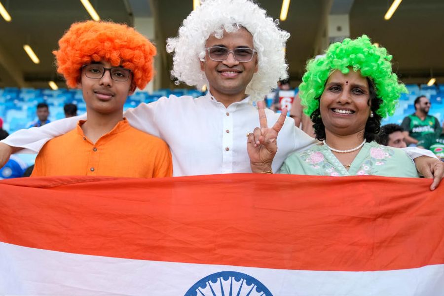 India's fans carry the Indian national flag as they wait for the Asia Cup cricket final between India and Pakistan to begin at Dubai International Cricket Stadium, United Arab Emirates, Sunday, Sept. 28, 2025. (