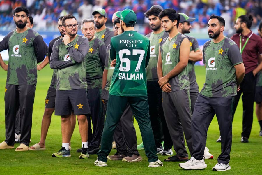 Pakistan's captain Salman Agha, his back to the camera, waits with teammates. the coach and the support staff for the presentation ceremony after India won the Asia Cup cricket final against Pakistan at Dubai International Cricket Stadium, United Arab Emirates, Sunday, Sept. 28, 2025.