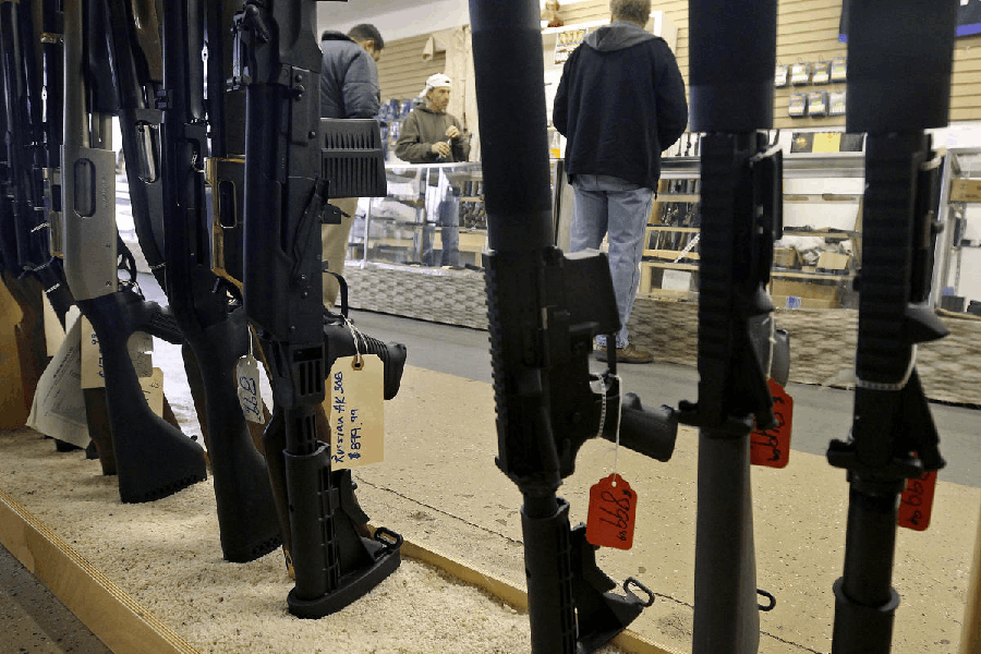 File photo: Customers are seen shopping for handguns through a rack of assault rifles at the Guns-R-Us gun shop in Phoenix, Arizona