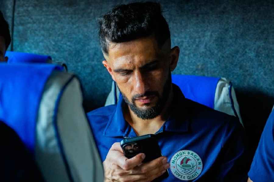 Mohun Bagan goalkeeper Vishal Kaith checks his phone during the bus journey to Jamshedpur. 