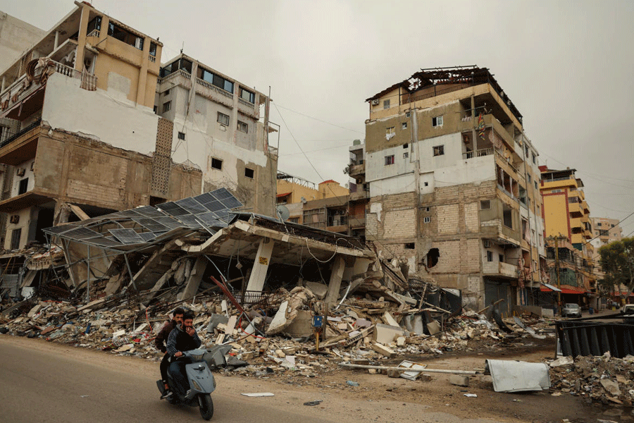 Men ride a scooter past the rubble of a building destroyed by an Israeli strike, amid escalating hostilities between Israel and Hezbollah, as the U.S.-Israeli conflict with Iran continues, in Tyre, Lebanon, April 2, 2026.
