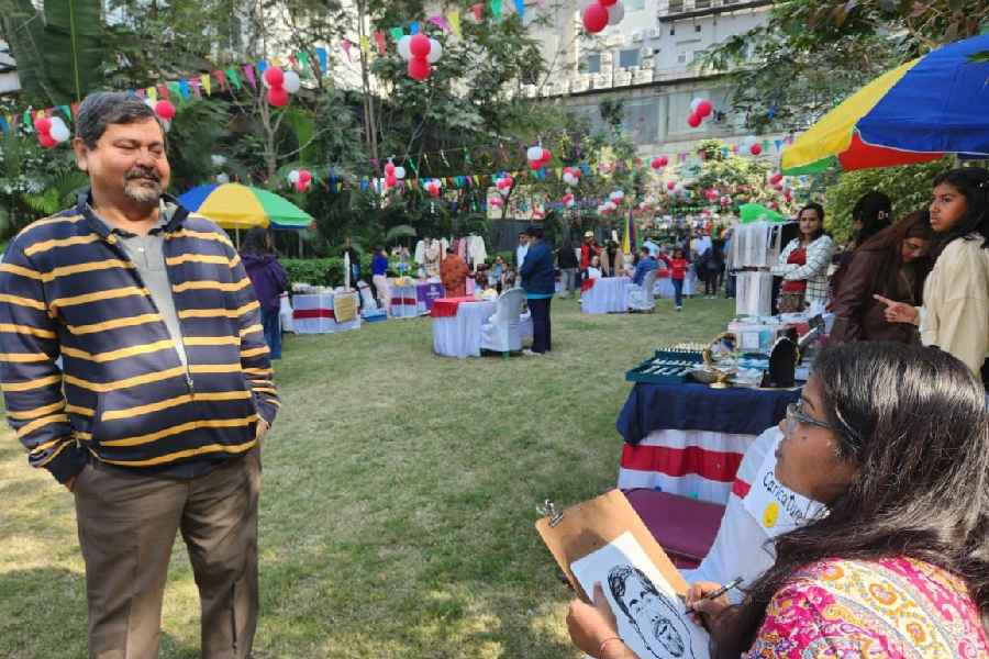 A visitor to the carnival at One Rajarhat gets his caricature sketched. 