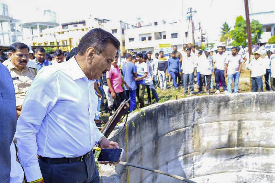 Maharashtra Water Resources Minister Girish Mahajan, centre, along with officials inspects the accident site in the Shivajinagar area of Dindori tehsil where nine members of a family, including six children, were allegedly killed after their car plunged into an open roadside well, in Nashik district, Saturday, April 4, 2026. (PTI)