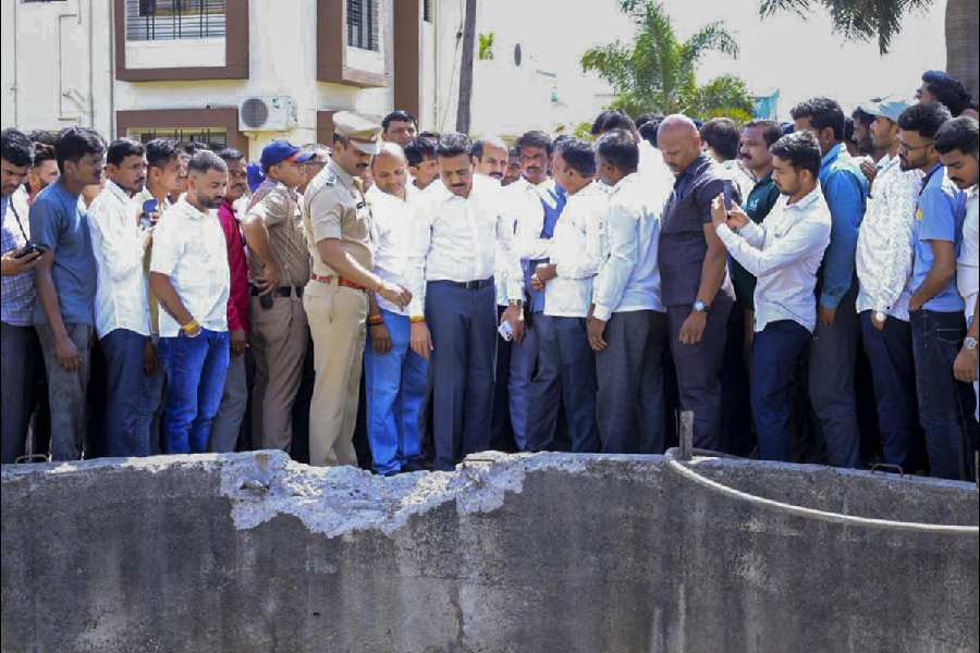 Maharashtra Water Resources Minister Girish Mahajan, centre, along with officials inspects the accident site in the Shivajinagar area of Dindori tehsil where nine members of a family, including six children, were allegedly killed after their car plunged into an open roadside well, in Nashik district, Saturday, April 4, 2026.