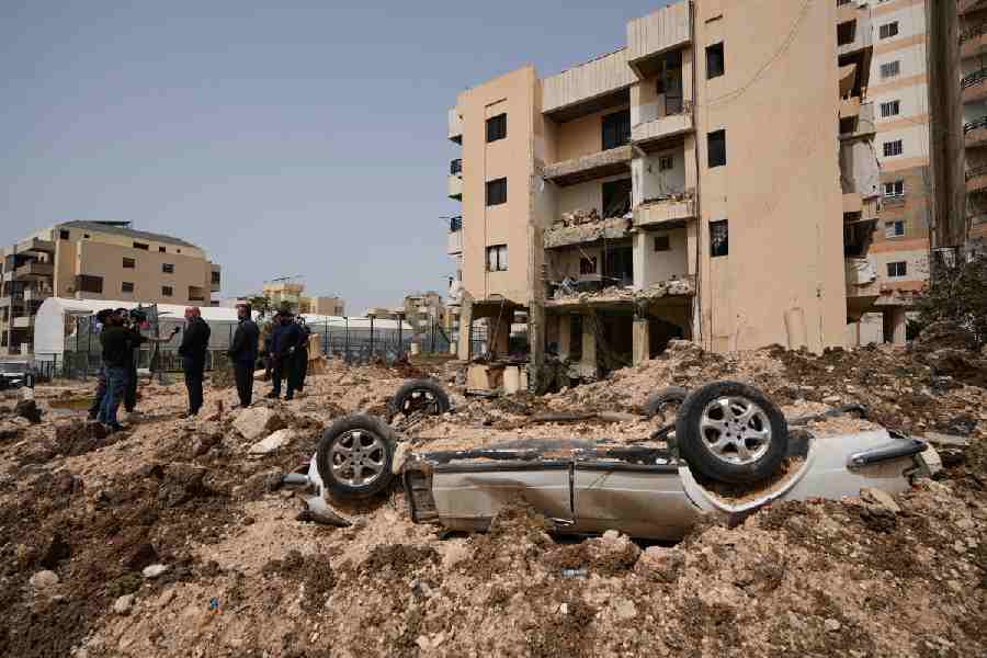 People gather at the site of an Israeli airstrike that hit a building in the southern port city of Tyre, Lebanon, Saturday, April 4, 2026.